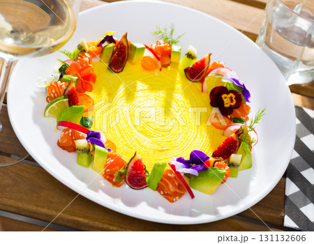 Tartar of raw salmon with ring from avocado and fresh vegetables and flowers 131132606