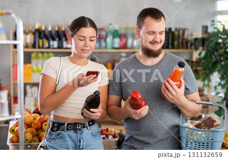 Couple scanning juice bottles Couple scanning juice bottles 131132659