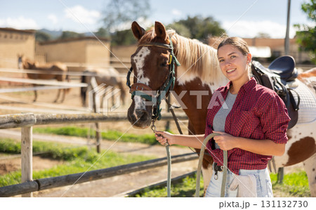 Young woman leads horse by bridle Young woman leads horse by bridle 131132730