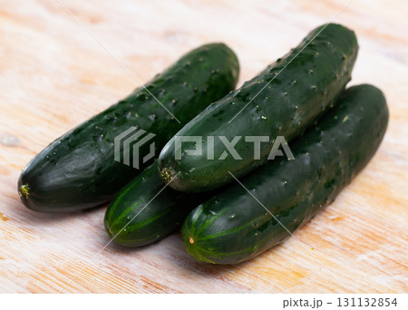 Fresh cucumbers on wooden table in home kitchen Fresh cucumbers on wooden table in home kitchen 131132854