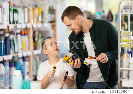 Schoolboy son and dad are choosing hand tools in store 131132904
