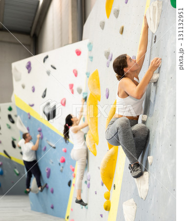 Young woman practicing rock climbing on climbing wall 131132951