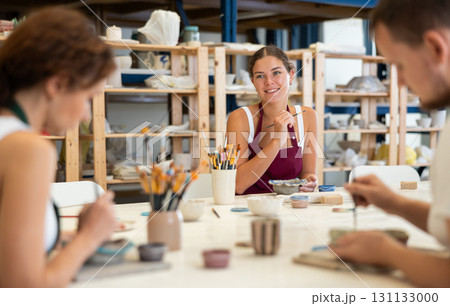 Three craftsperson are busy painting clay products Three craftsperson are busy painting clay products 131133000