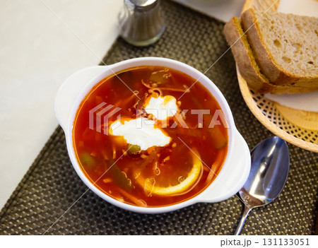 Traditional Russian meat soup Solyanka with sour cream and lemon 131133051