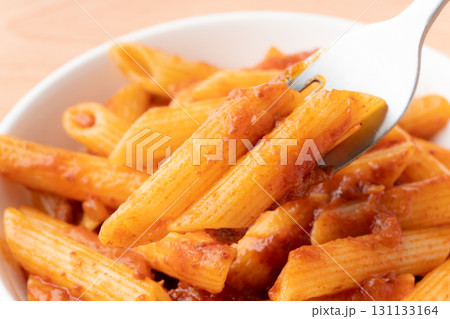 フォークに載せたミートソースのペンネのクローズアップ 131133164