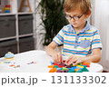 Child Engaged in Creative Play with Colorful Geometric Shapes 131133302