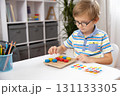 Child Engaged in Educational Puzzle Activity at Home 131133305