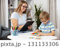 Child Engaged in Educational Activity with Teacher in Classroom Setting 131133306