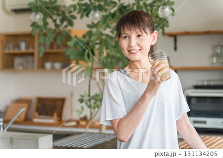 健康維持のためスムージー,野菜ジュースを飲む中高年の女性 131134205