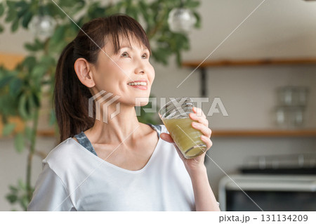 健康維持のためスムージー,野菜ジュースを飲む中高年の女性 131134209