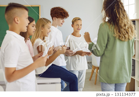 School children in classroom with teacher singing in choir during music lesson. School children in classroom with teacher singing in choir during music lesson. 131134377