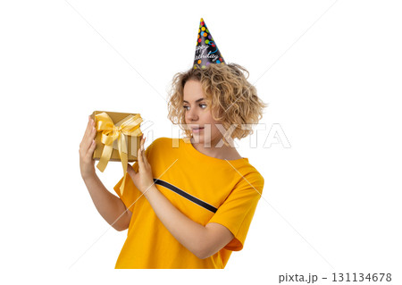 Woman looks at a beautifully wrapped gift box, isolated on white, PNG 131134678