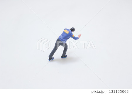 Miniature Toy Figure in Blue Jacket Performing a Stretch Pose Miniature Toy Figure in Blue Jacket Performing a Stretch Pose 131135063