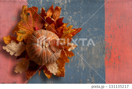Rustic Autumn Display of Pumpkin and Colorful Leaves on Wooden Background. File with Clipping Path. Rustic Autumn Display of Pumpkin and Colorful Leaves on Wooden Background. File with Clipping Path. 131135217