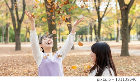 落ち葉で遊ぶ若い女性 131135640