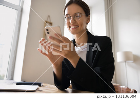 Portrait beautiful successful millennial businesswoman sitting at desk using phone Portrait beautiful successful millennial businesswoman sitting at desk using phone 131136004