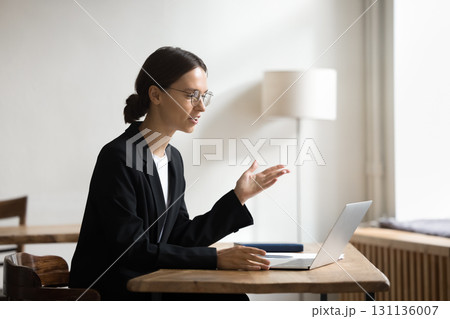 Young businesswoman having online meeting with client via notebook webcam 131136007
