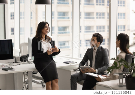Confident senior female boss explaining tasks to young employees Confident senior female boss explaining tasks to young employees 131136042