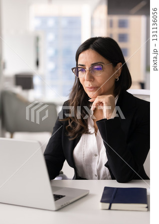 Focused middle aged executive woman thinking on business company management Focused middle aged executive woman thinking on business company management 131136056
