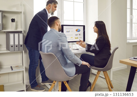 Business people discussing financial diagram, charts on pc computer screen in office. Business people discussing financial diagram, charts on pc computer screen in office. 131136653