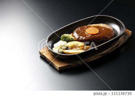 付け合わせでポテトフライ、ポテトサラダ、ブロッコリーが乗ってるハンバーグプレートを黒背景で撮影 付け合わせでポテトフライ、ポテトサラダ、ブロッコリーが乗ってるハンバーグプレートを黒背景で撮影 131136730