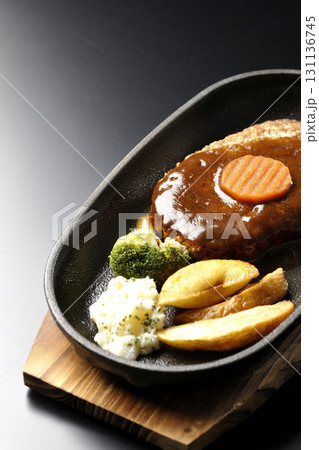 付け合わせでポテトフライ、ポテトサラダ、ブロッコリーが乗ってるハンバーグプレートを黒背景で撮影 付け合わせでポテトフライ、ポテトサラダ、ブロッコリーが乗ってるハンバーグプレートを黒背景で撮影 131136745