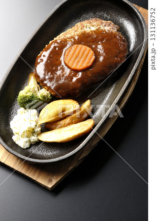 付け合わせでポテトフライ、ポテトサラダ、ブロッコリーが乗ってるハンバーグプレートを黒背景で撮影 付け合わせでポテトフライ、ポテトサラダ、ブロッコリーが乗ってるハンバーグプレートを黒背景で撮影 131136752