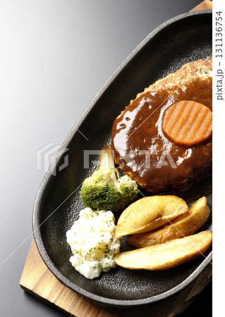付け合わせでポテトフライ、ポテトサラダ、ブロッコリーが乗ってるハンバーグプレートを黒背景で撮影 131136754