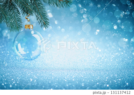Christmas bauble on spruce branch with blue winter background. Holiday bauble on spruce with sparkling festive lights, Christmas background with shining blue bokeh 131137412