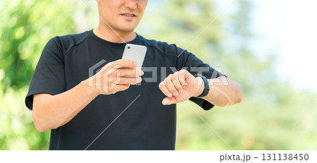 スマートウォッチを使い健康管理・ヘルスケアをするスポーツウェア姿の中年男性 131138450