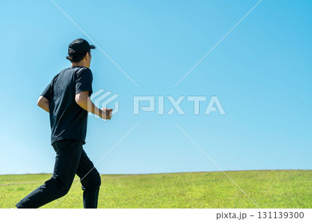 青空の下でランニング・ジョギングをする男性（アスリート・有酸素運動・ワークアウト・フィットネス） 131139300
