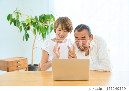 テレビ電話をする熟年夫婦 テレビ電話をする熟年夫婦 131140329