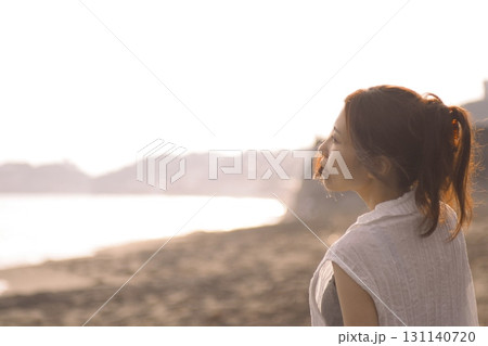 湘南海岸・夕暮れの海辺の一人の女性 131140720