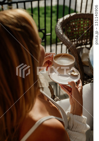 Woman Coffee Balcony Enjoying a cup of coffee on a balcony. 131140906