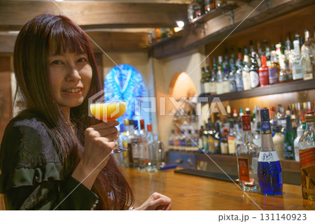 オーセンティックバーで一人お酒を味わう女性 131140923