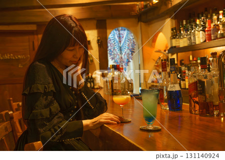 オーセンティックバーで一人お酒を味わう女性 131140924