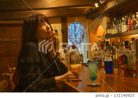 オーセンティックバーで一人お酒を味わう女性 131140925