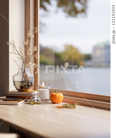 Flowering branch in vase and halloween pumpkin with candles on wooden table aside window in sunlight 131141033