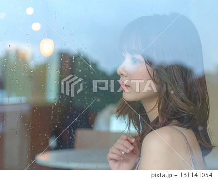 窓越しに雨を見つめる女性のポートレート 131141054