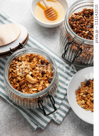 Granola with nuts and dried fruits in glass jars Granola with nuts and dried fruits in glass jars 131142010