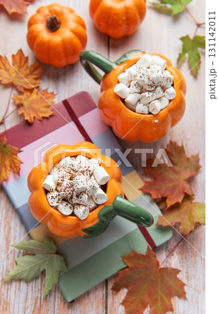 Pumpkin mugs with hot chocolate and marshmallows, autumn concept 131142011