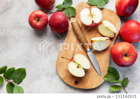Fresh red apples and slices with knife on wooden cutting board 131142015