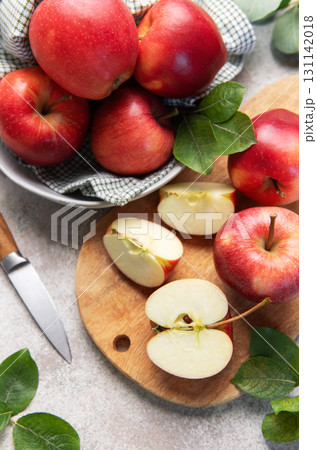 Red apples, whole and sliced, on cutting board 131142018