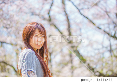 満開の桜の中にいる日本人中年女性 131142111