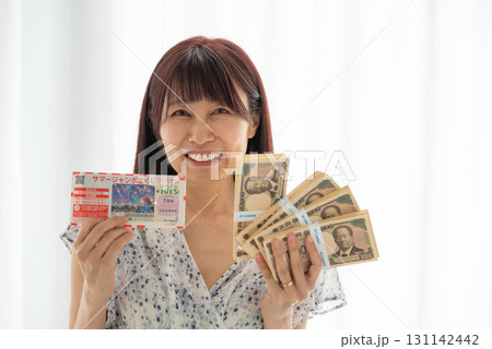 宝くじ高額当選して新札札束(渋沢栄一)を握る女性 宝くじ高額当選して新札札束(渋沢栄一)を握る女性 131142442