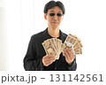 新札の一万円札札束を握る黒ずくめの男 新札の一万円札札束を握る黒ずくめの男 131142561