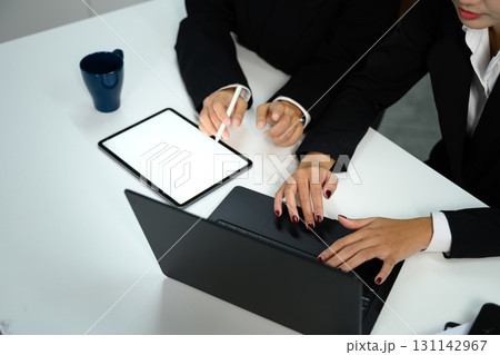 Coworkers analyzing data on digital tablet for corporate planning Coworkers analyzing data on digital tablet for corporate planning 131142967