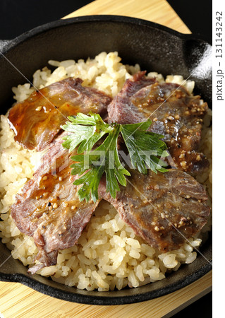 焼き肉乗せガーリックライスを黒背景で撮影 131143242