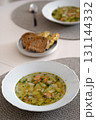Homemade salmon soup with potatoes and herbs, served in white bowl on dining table 131144332
