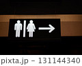 Restroom sign featuring male and female symbols with directional arrow for guidance 131144340